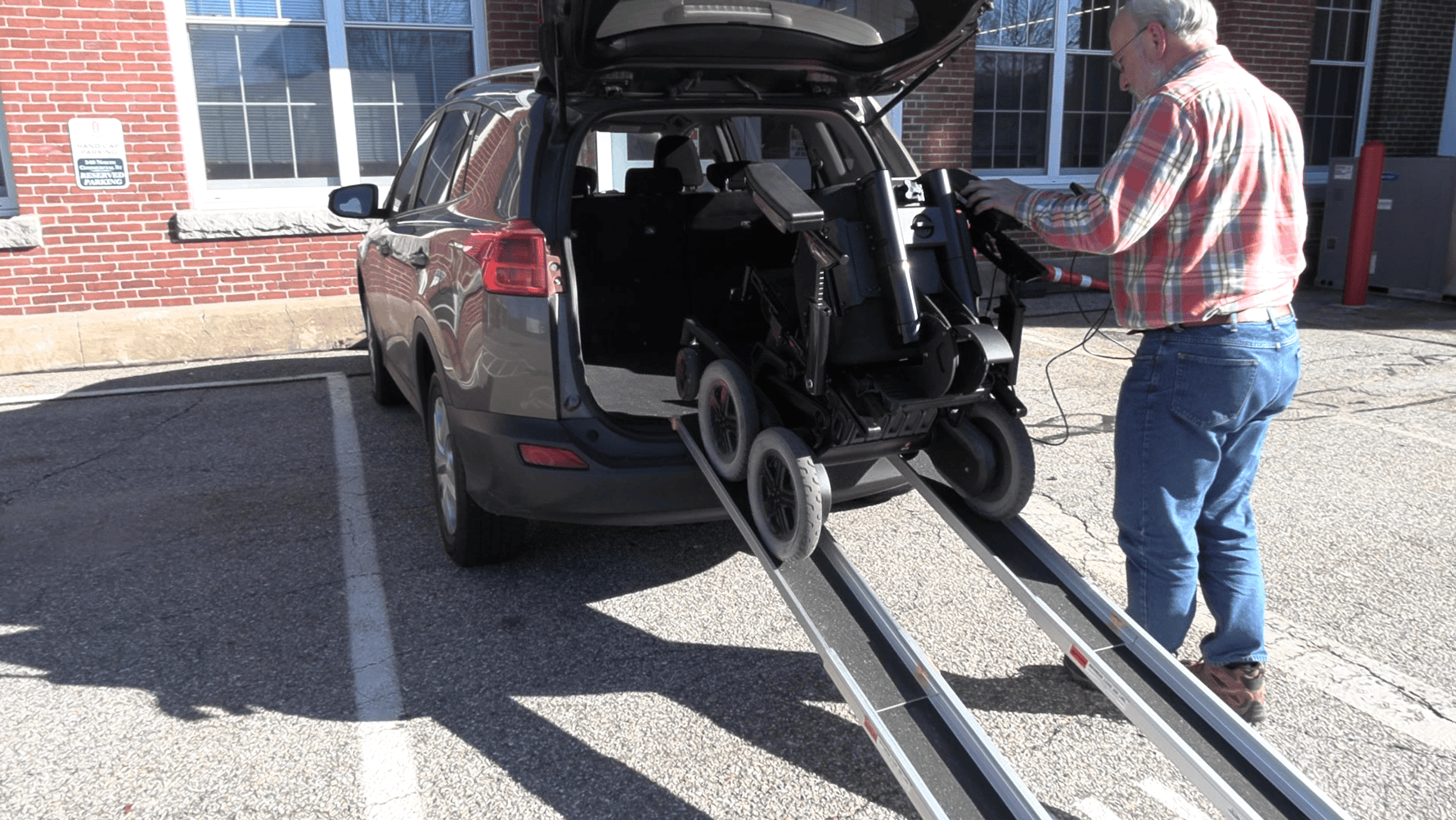 Clinician loading an iBOT into a vehicle using Remote Mode.